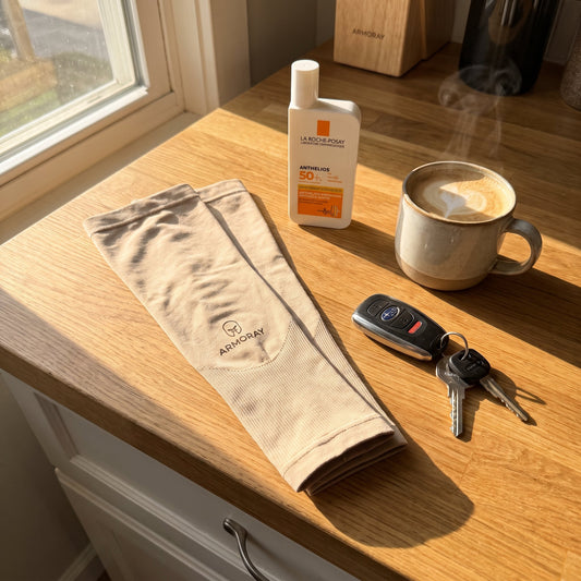 Morning kitchen counter with sunscreen bottle, arm sleeves, car keys, and a coffee mug in warm morning light.