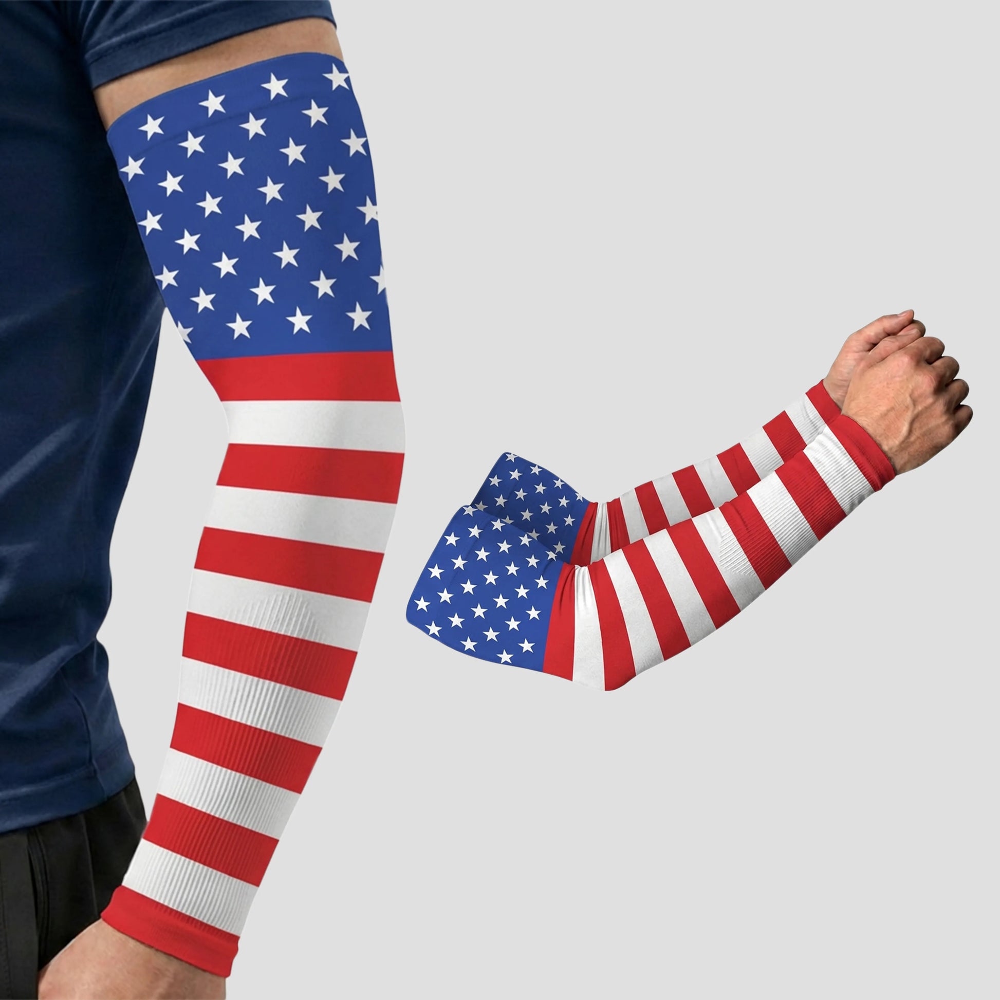 Two arms wearing ARMORAY Armoray® Patterned Arm Sleeves in an American flag design—blue with white stars on the upper arm and red and white stripes on the lower arm—are shown against a plain background. These sleeves deliver UPF 50+ sun protection, making them both stylish and functional.