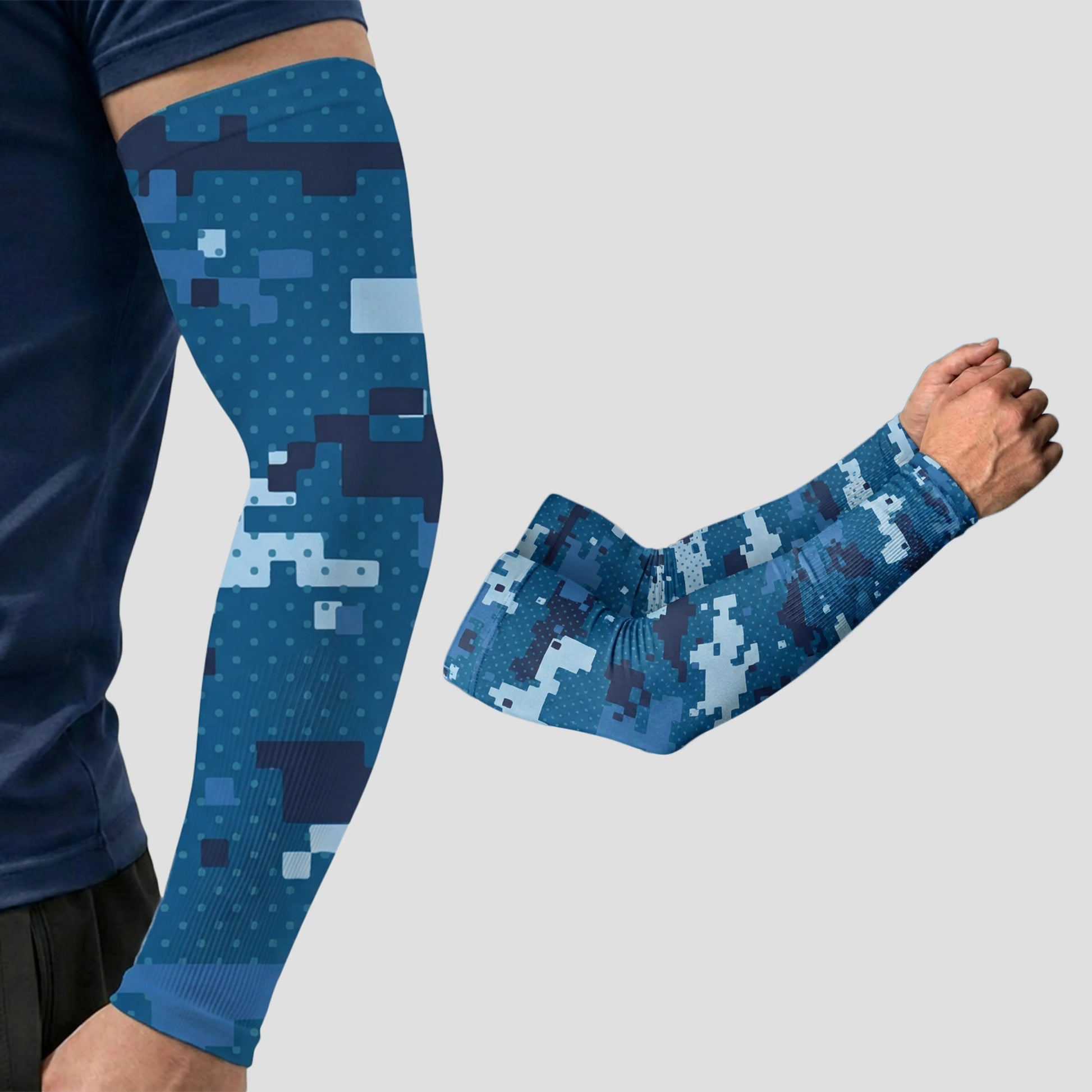 Two blue digital camouflage print ARMORAY Armoray® Patterned Arm Sleeves are shown—one worn on an arm, the other displayed separately on a light gray background. These bold sleeves offer UPF 50+ sun protection, blending style and functionality for outdoor activities.