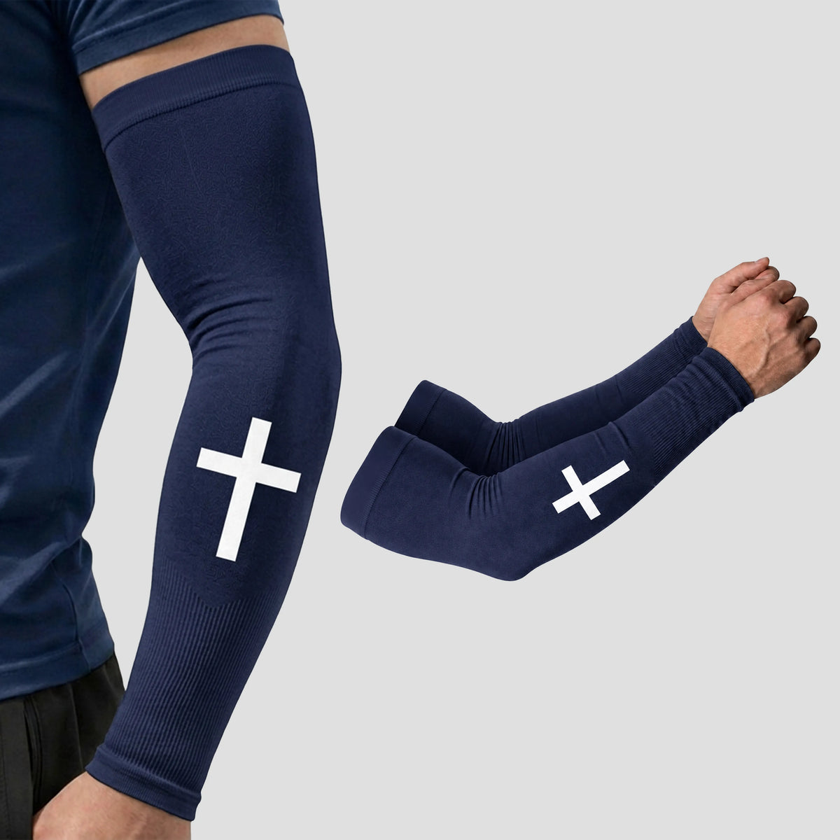 Introducing the ARMORAY Faith Series: navy blue compression arm sleeves adorned with a bold white cross design. Crafted from moisture-wicking fabric and offering UPF 50+ sun protection, these scripture sleeves combine style and performance. Shown both on a model and individually against a clean backdrop, the Faith Series by ARMORAY is designed for comfort and faith-inspired athletic wear.