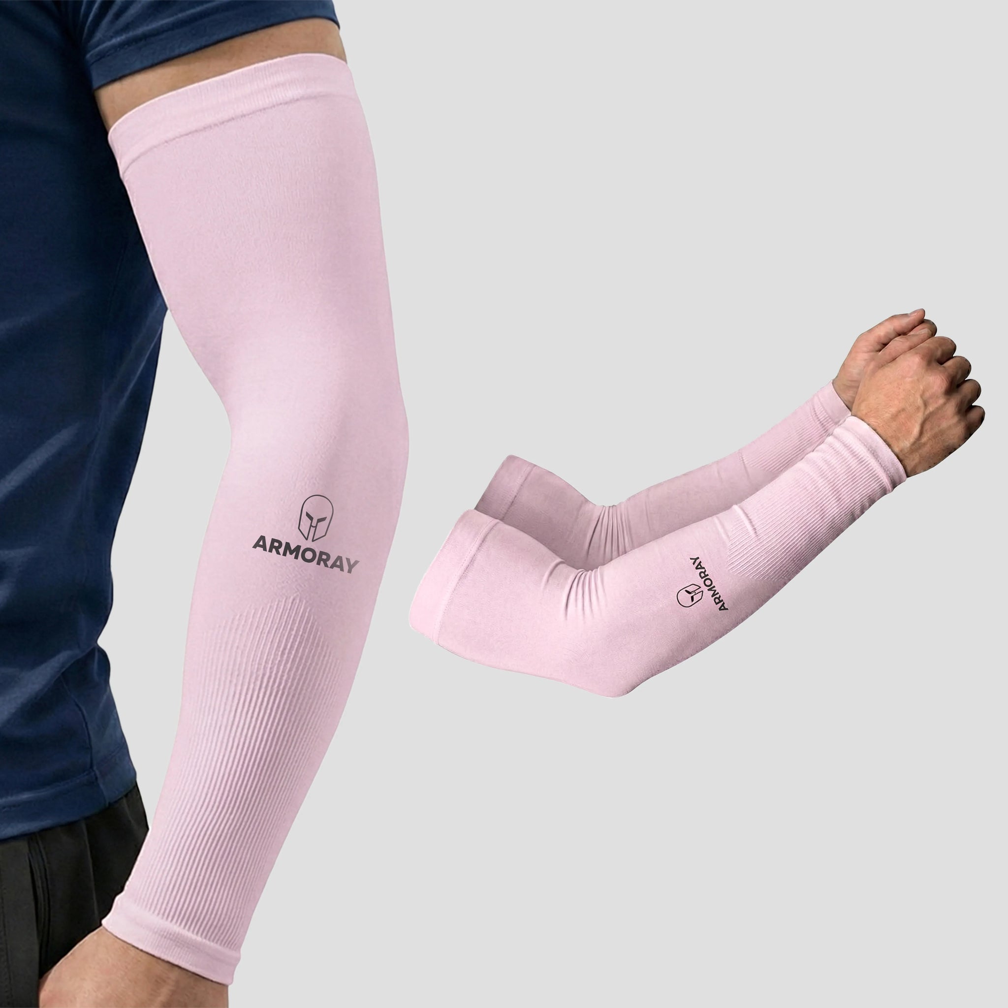 Two arms wearing light pink ARMORAY Armoray® Classic Arm Sleeves, designed for comfort and protection—one arm bent, the other straight—against a plain gray background.