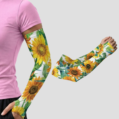 A person is wearing Armoray® Garden Collection Arm Sleeves — Designed to Delight Outdoors by ARMORAY, featuring a sunflower pattern, with one arm extended; a second sleeve—highlighting its UPF 50+ sun protection—is shown separately on a plain background.