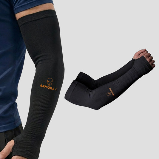 Wearing the Armoray® Thumbhole Arm Sleeves — Designed for Total Protection by ARMORAY, a person showcases the black compression sleeve with extended hand coverage and a comfortable thumbhole design for enhanced support. Beside them lies a matching pair of identical sleeves on a plain background, making these sleeves perfect for sun protection during outdoor activities.