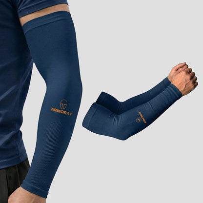 Wearing an Armoray® Classic Arm Sleeve by ARMORAY in navy blue—with the brand’s name and logo—the individual stays cool, comfortable, and protected; a pair of matching sleeves is shown next to their arm.