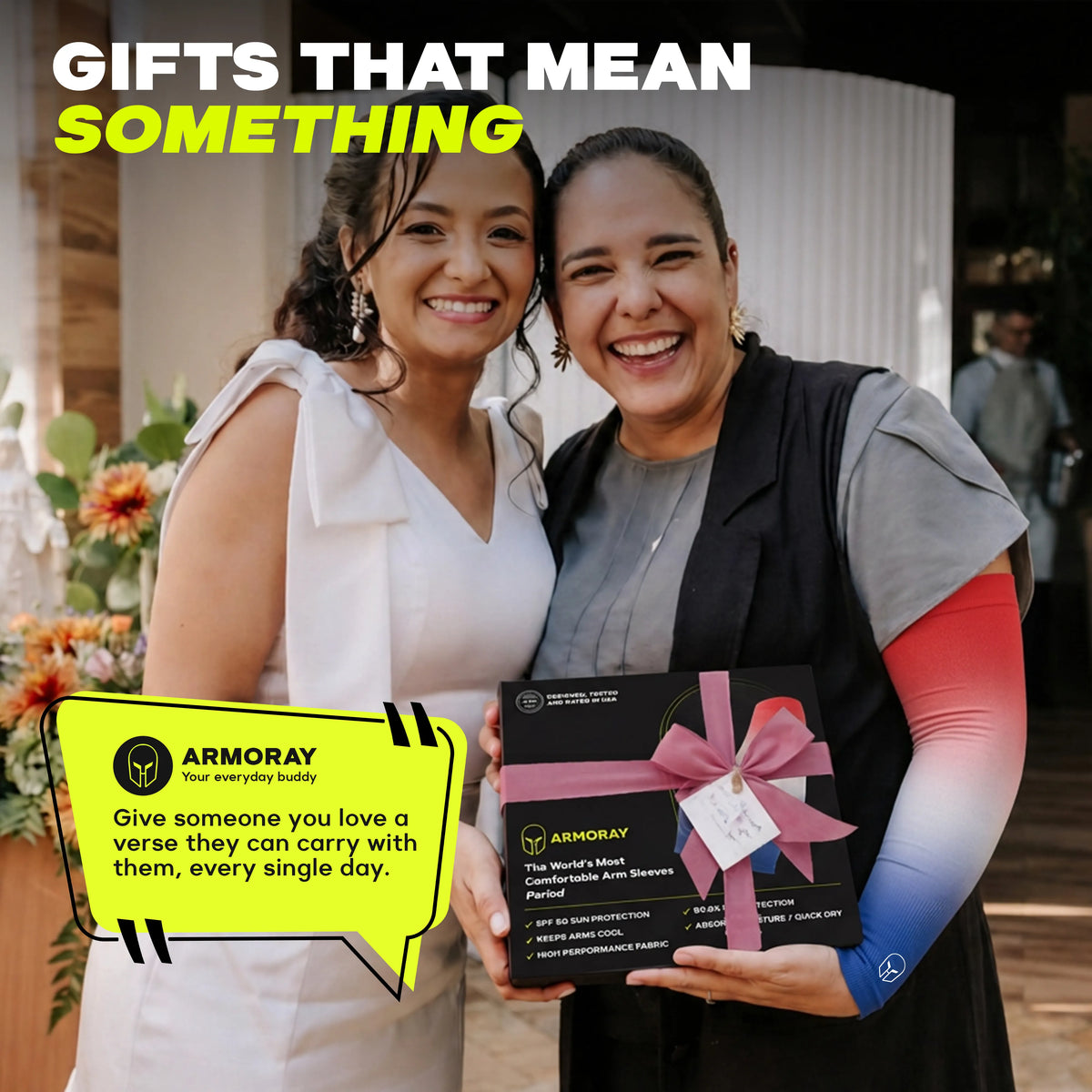 Two smiling women pose indoors; one holds a boxed ARMORAY Gradient Arm Sleeves gift set adorned with a pink bow. Text on the image promotes meaningful gifts, featuring a brief description highlighting UPF 50+ gradient arm sleeves that offer stylish UV protection for any occasion.