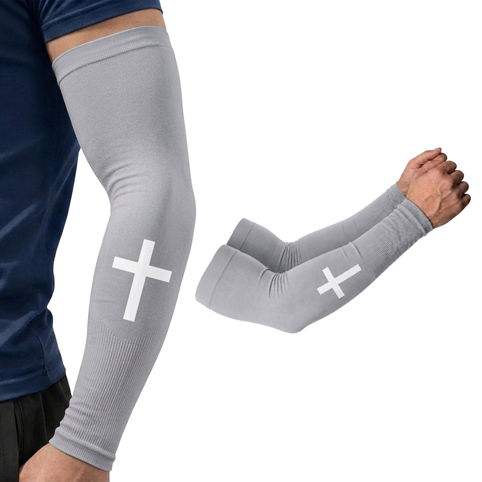 A person is wearing the ARMORAY Faith Series gray arm compression sleeve with a white cross, made from moisture-wicking fabric for all-day comfort, shown next to a matching pair of sleeves on a white background.
