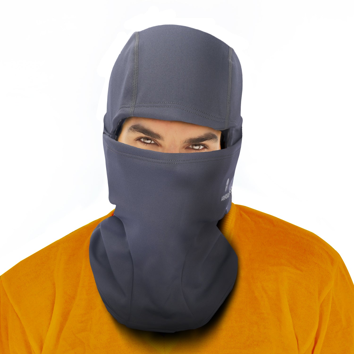 Person wears an ARMORAY Basics BALACLAVA in dark gray, fleece-lined and covering head, neck, and lower face for winter protection—only eyes visible—with an orange shirt.