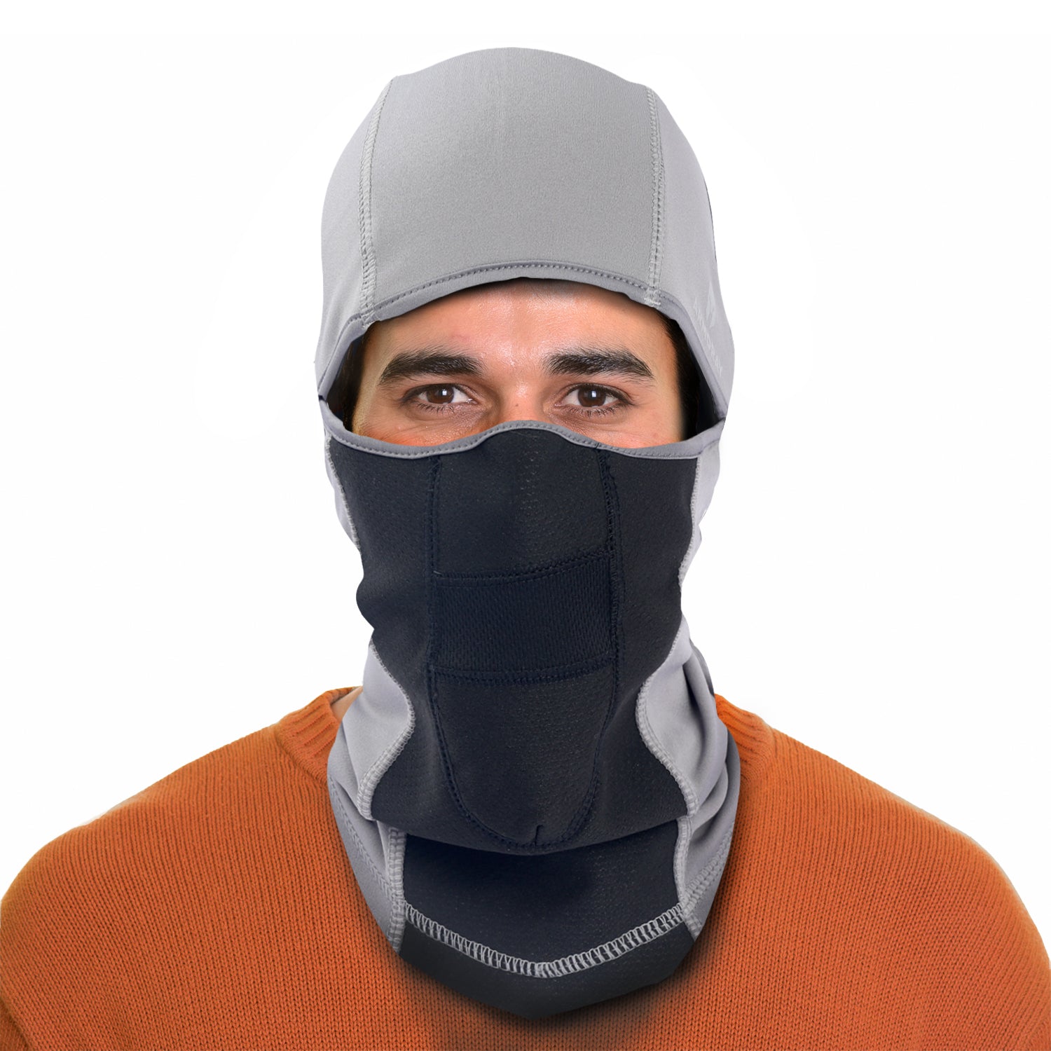 A person faces the camera against a white background, wearing the ARMORAY Basics BALACLAVA in gray and black fleece over their head and face, paired with an orange sweater.