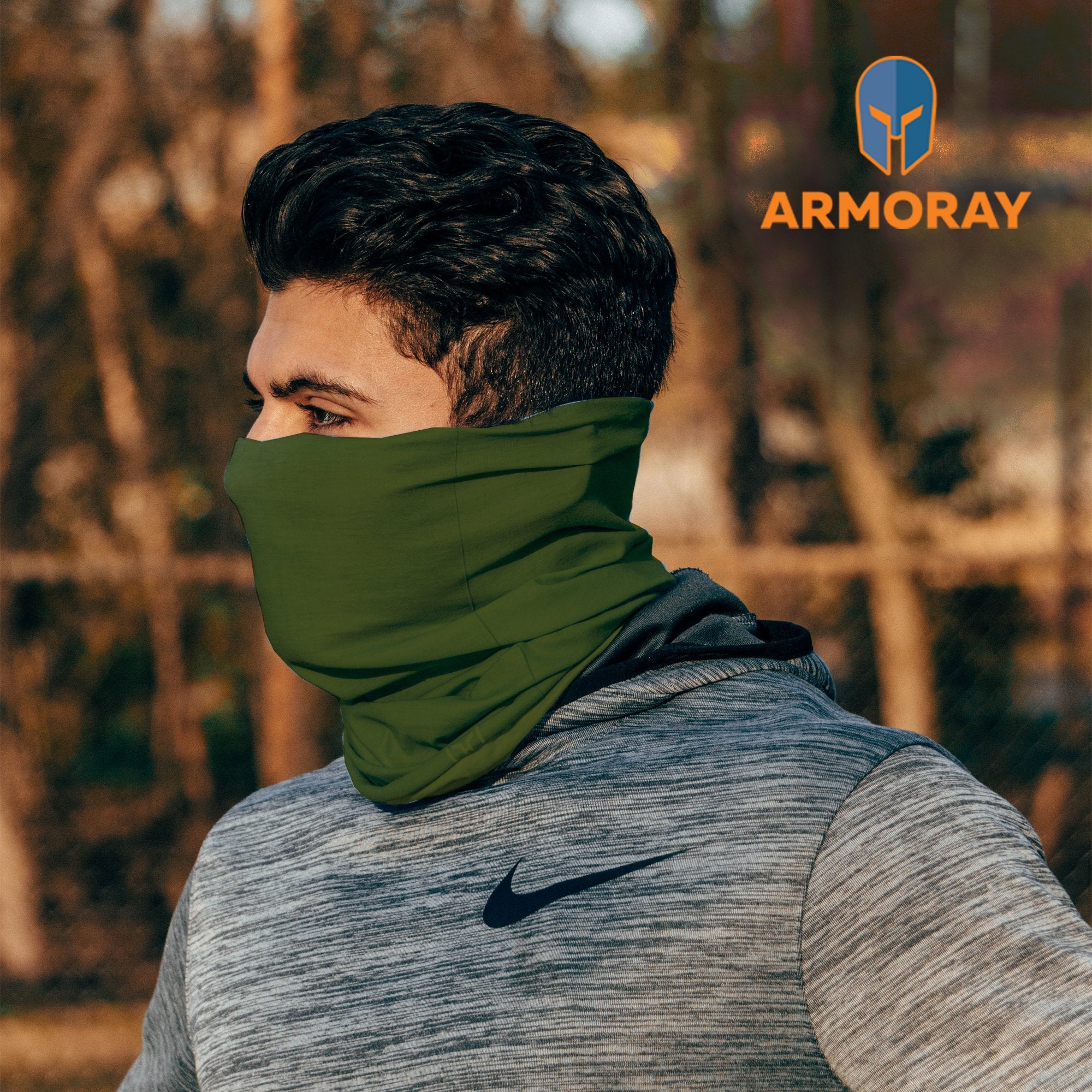Sure! Here’s a rewritten version of your sentence using the provided product data: Outdoors, a person in a gray Nike hoodie wears an Armoray® Bandana from ARMORAY as a green neck gaiter. In the top right corner, the ARMORAY logo emphasizes the bandana’s sweat-resistant design and its durability for outdoor use.