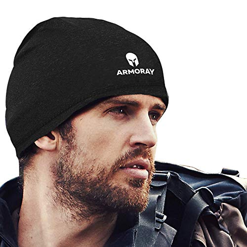 A man wearing the ARMORAY Basics Armoray Skull Cap—a black, sweat-wicking running hat beanie—looks to the side with a backpack, combining comfort and style for any adventure.